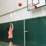 boy playing basketball alone on a court