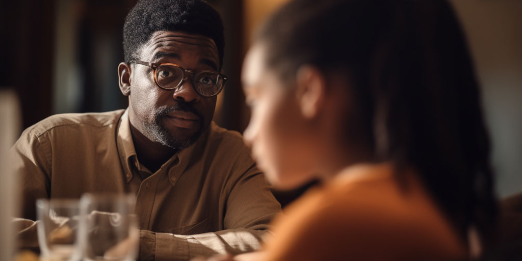 Father and daughter having a conversation at dinner