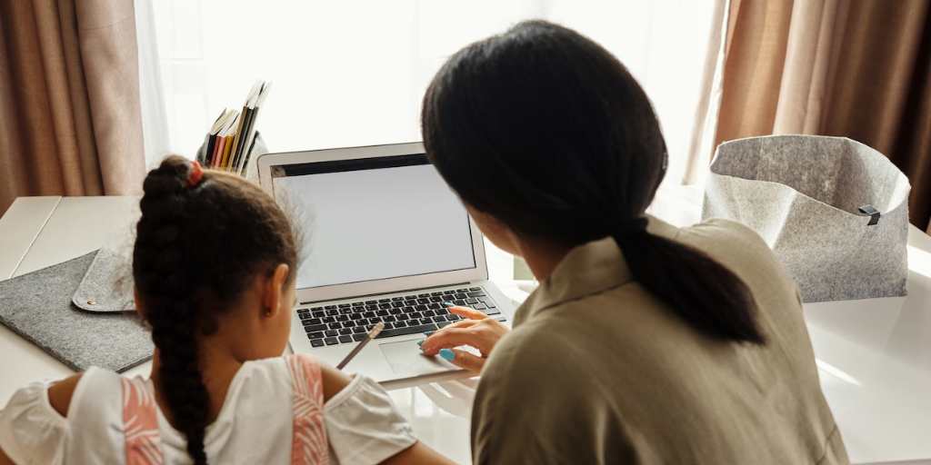 Mom and daughter working at laptop