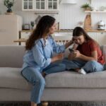 Parent talking to daughter on couch