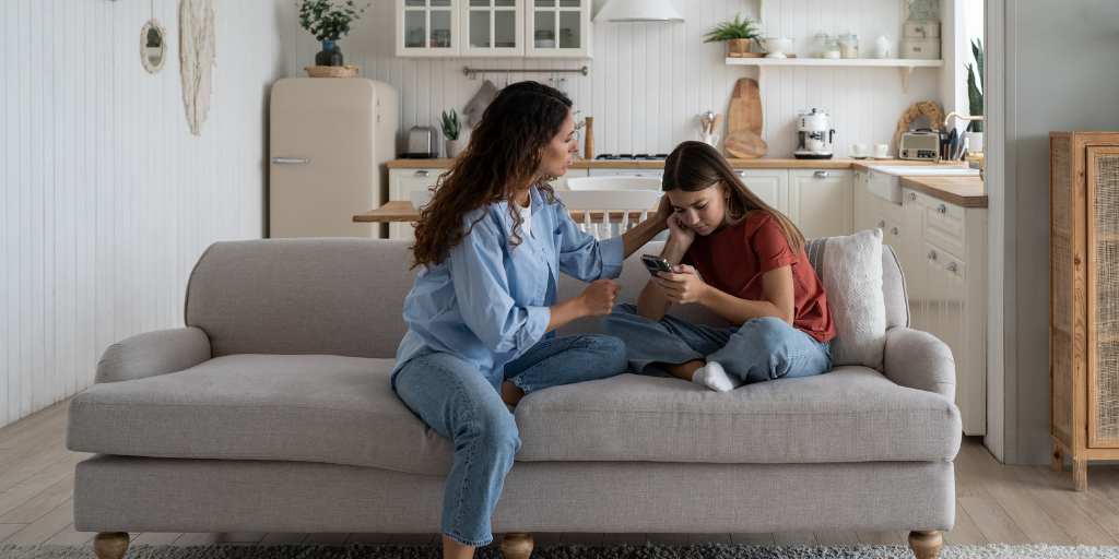 Parent talking to daughter on couch