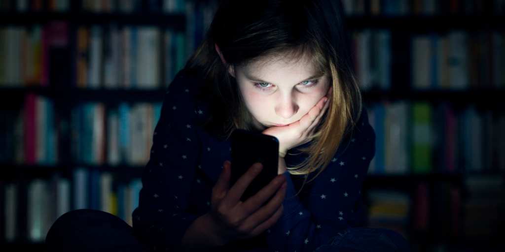 Child looking at phone in the dark
