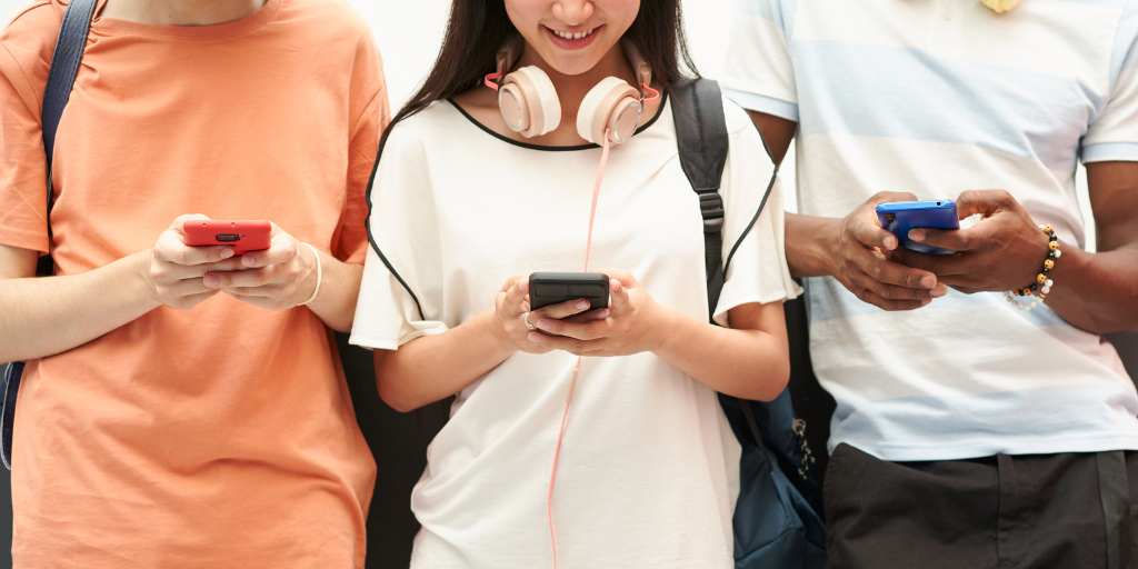 Three kids using smartphones