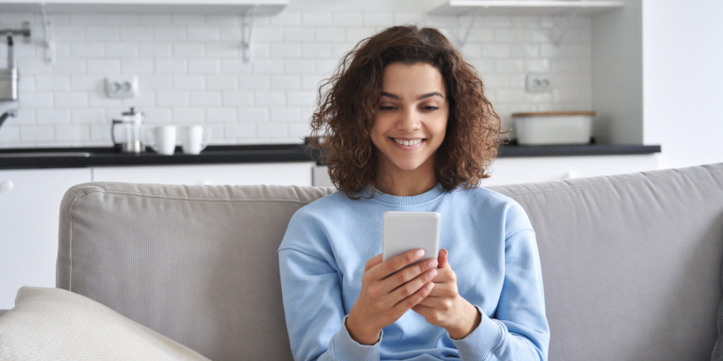 Teen using phone on couch