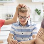 parents with son at table while mother ruffles child's hair