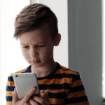 worried child looking at phone