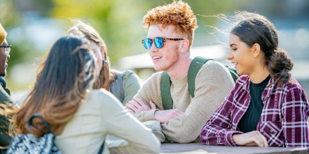 Teenagers sitting at table together