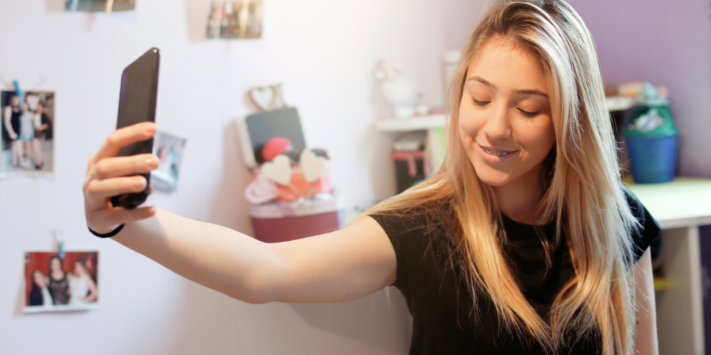 Teen girl taking a selfie with phone