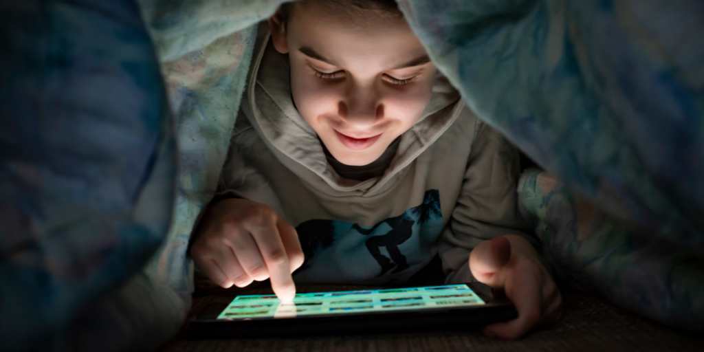 Child using tablet in bed