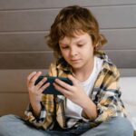Boy using phone with Apple Screen Time