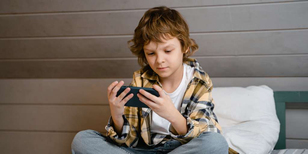 Boy using phone with Apple Screen Time