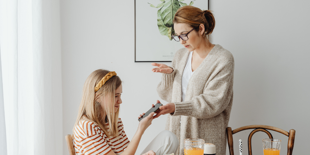 Mother holding out phone to child