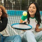 two teens playing tennis without any devices nearby
