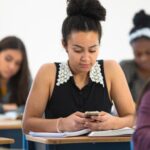 teen girl on phone in class