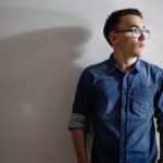 teen boy standing in front of wall