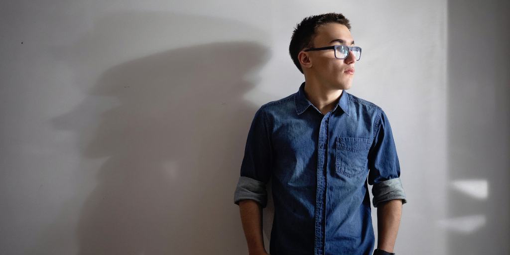 teen boy standing in front of wall