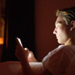 Teen talking to AI chatbot companion in bed after dark