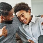 Father and son talking together on couch about BrightCanary Keyboard