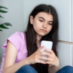 Teen girl texting on iPhone