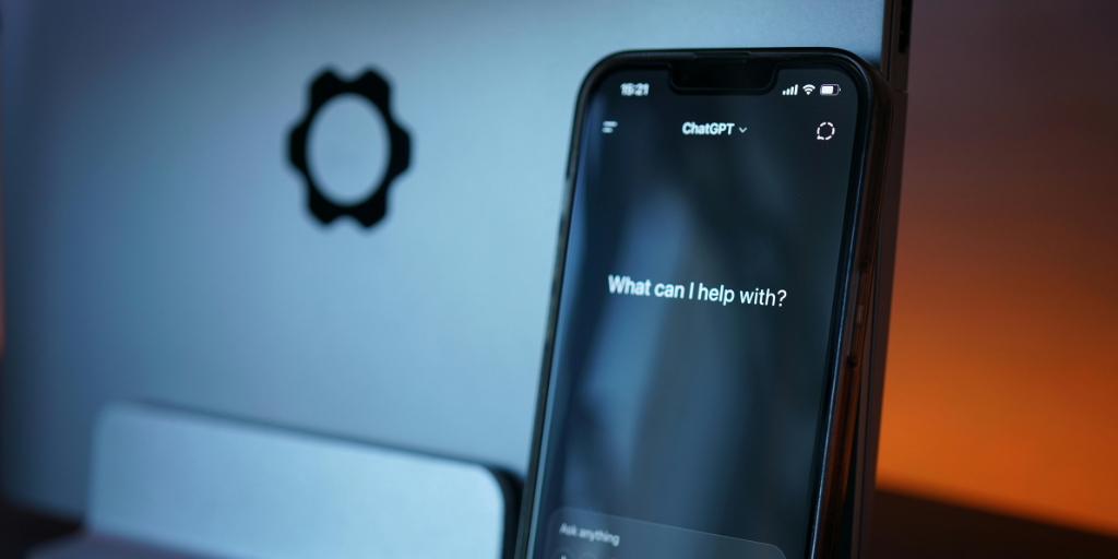 Phone with ChatGPT in front of laptop