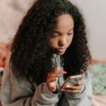 Teen girl on iPhone in bedroom