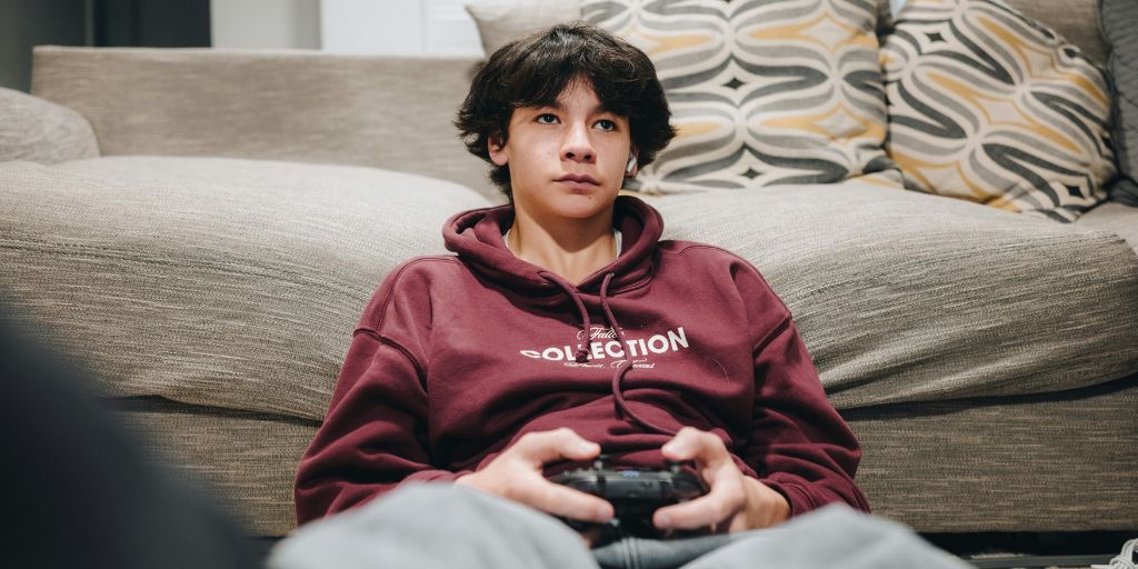 Teen boy gaming in front of couch